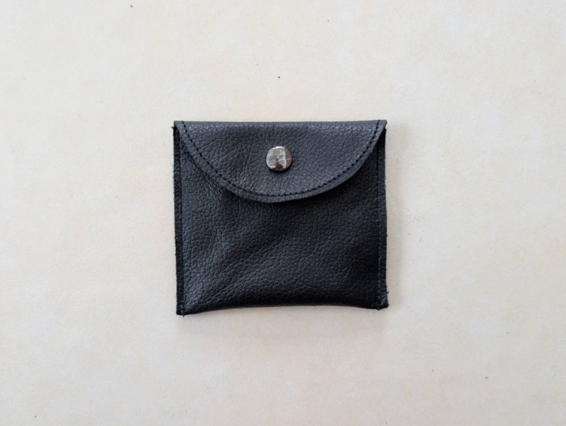 Black leather rosary case showing the front popper closure and unembroidered side